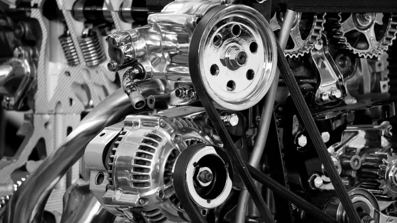 Motor de coche en blanco y negro con poleas, correas y alternador cromados